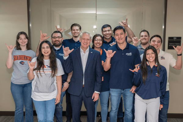 Alvarez alum, Derek Schriver, poses with "Birds Up" hand sign alongside Dean Jonathon Halbesleben and fellow Alvarez alumni whom Schriver employs at his accounting firm.