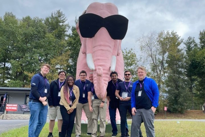 Cyber Competition Team standing in front of large pink elephant statue