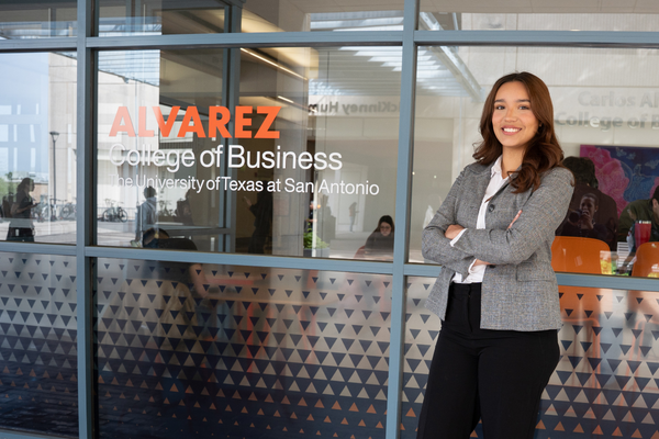 Photo of female student in suit smiling in front of Business Building