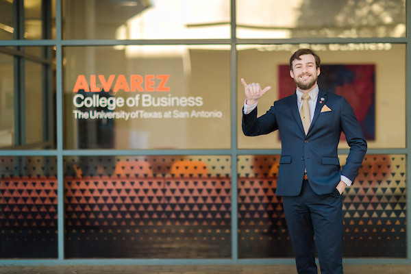Male student in suit in front of UTSA Business Building
