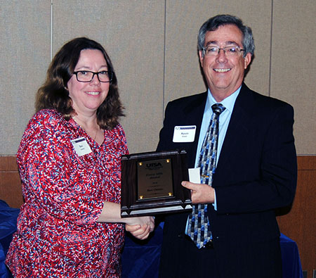 Bev Ostmo receives her award from Associate Dean Kevin Grant.