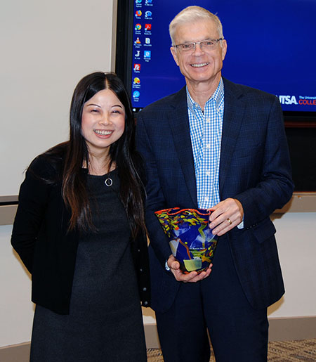 Melody Lo presents Ken Weiher with his retirement gift.