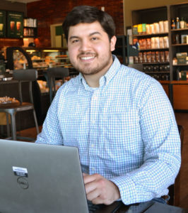Giovanni Serrato with laptop in coffee shop
