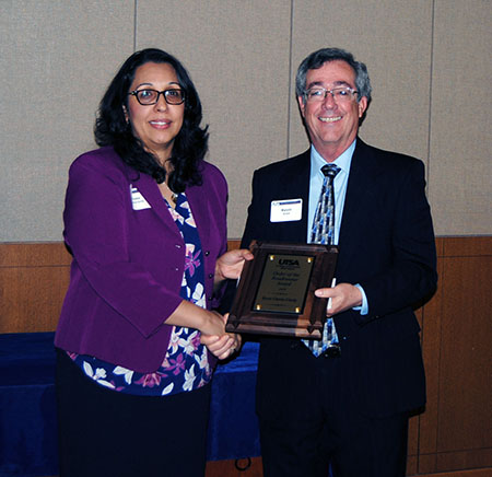Rosa Garza-Girdy receives her award from Associate Dean Kevin Grant.