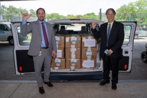 Don Lien, the Richard S. Liu Distinguished Chair in Business at UTSA, (right) presents Brandon Hartman, senior director of ACO and business development at UT Health San Antonio (left) with the medical masks donated by Liu Program alumni.