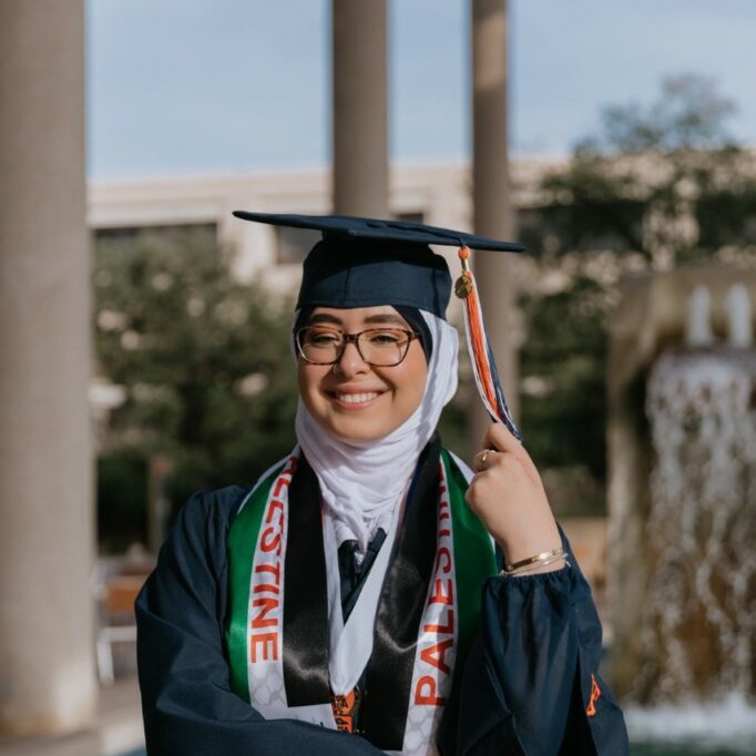Image of graduate Farah Hamed for December 2022 graduate student profiles, wearing cap and gown in front of the waterfall in the Sombrilla