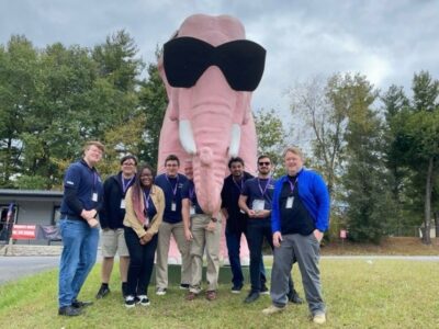 Photo of competition team with large pink elephant wearing sunglasses