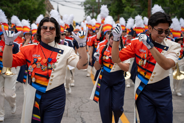 UT San Antonio SOSA marching band drum majors dancing at the annual Fiesta Flambeau Parade.