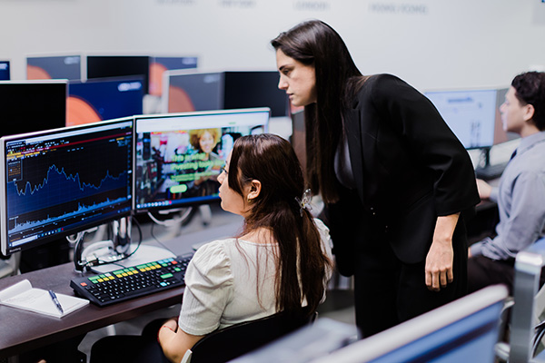 Two women working on a Bloomberg computer terminal.